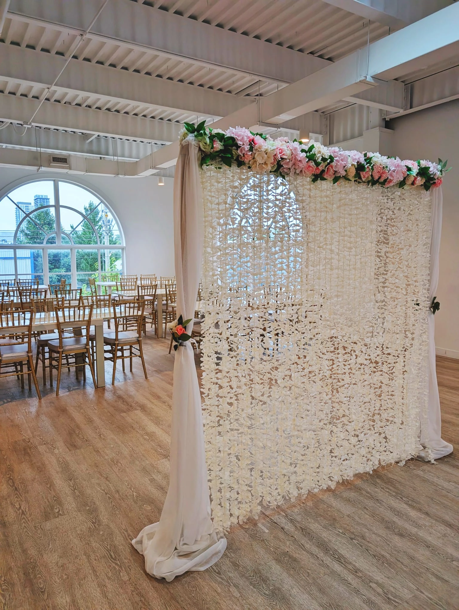 The Essential Nikkah Wall with full chiffon draping, dividing a banquet hall set with gold chiavari chairs
